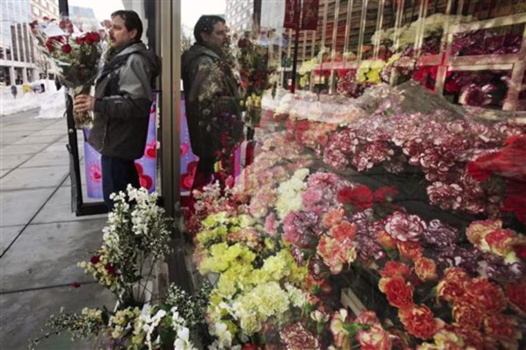 Jim Caruso takes a completed Valentine's Day bouquet to be chilled at Caruso Florist in Washington, on Thursday, Feb. 11, 2010. The shop rented four wheel drive vehicles in order to pick up employees and make deliveries in the wake of back to back snow storms. (AP Photo/Jacquelyn Martin)